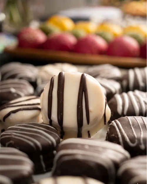 Alfajores de cóctel bañados en chocolate, repostería artesanal para eventos en Santiago.
