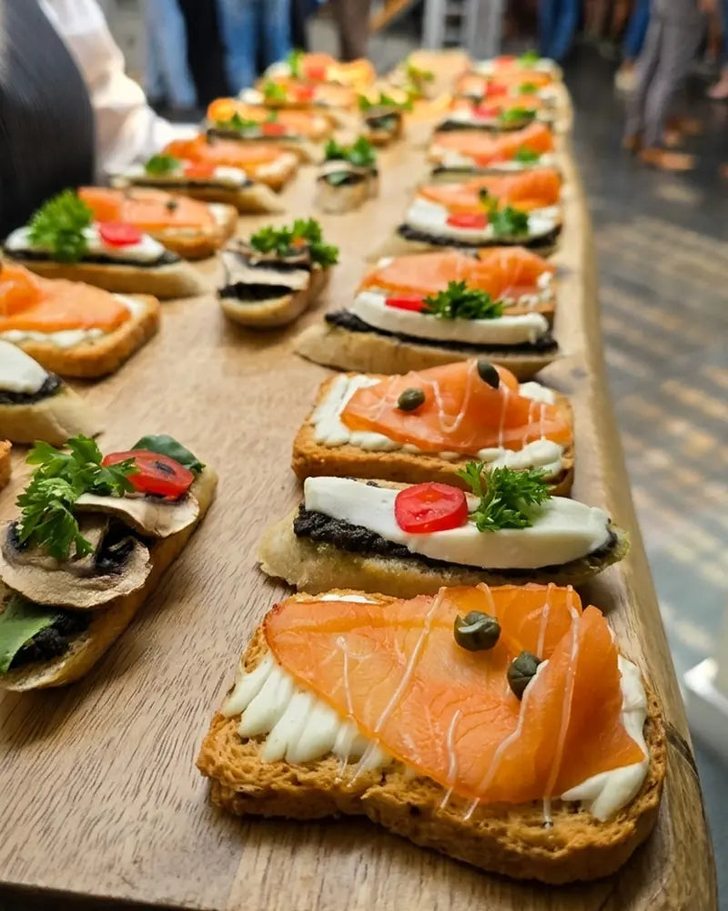 Canapé gourmet de salmón ahumado sobre pan tostado, catering de bodas en Santiago.