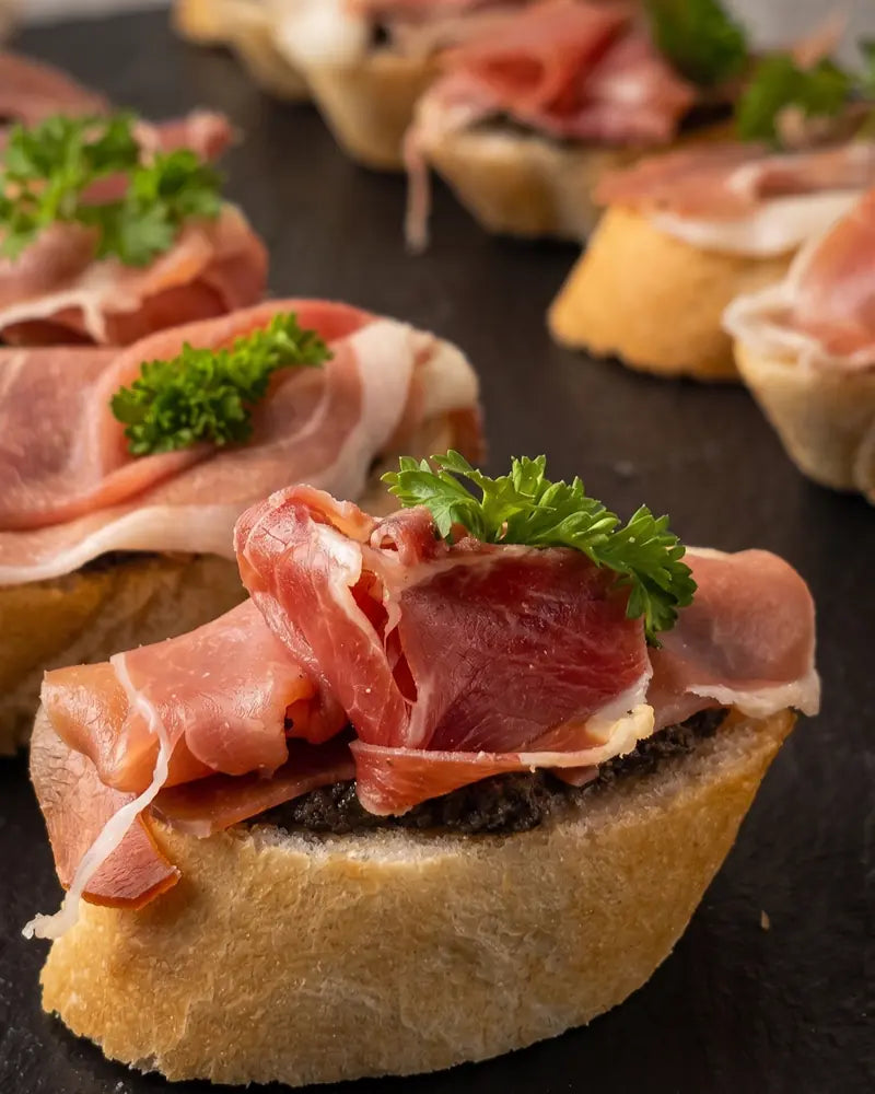 Bruschettas de jamón serrano con aceite de oliva para catering a domicilio en Santiago.